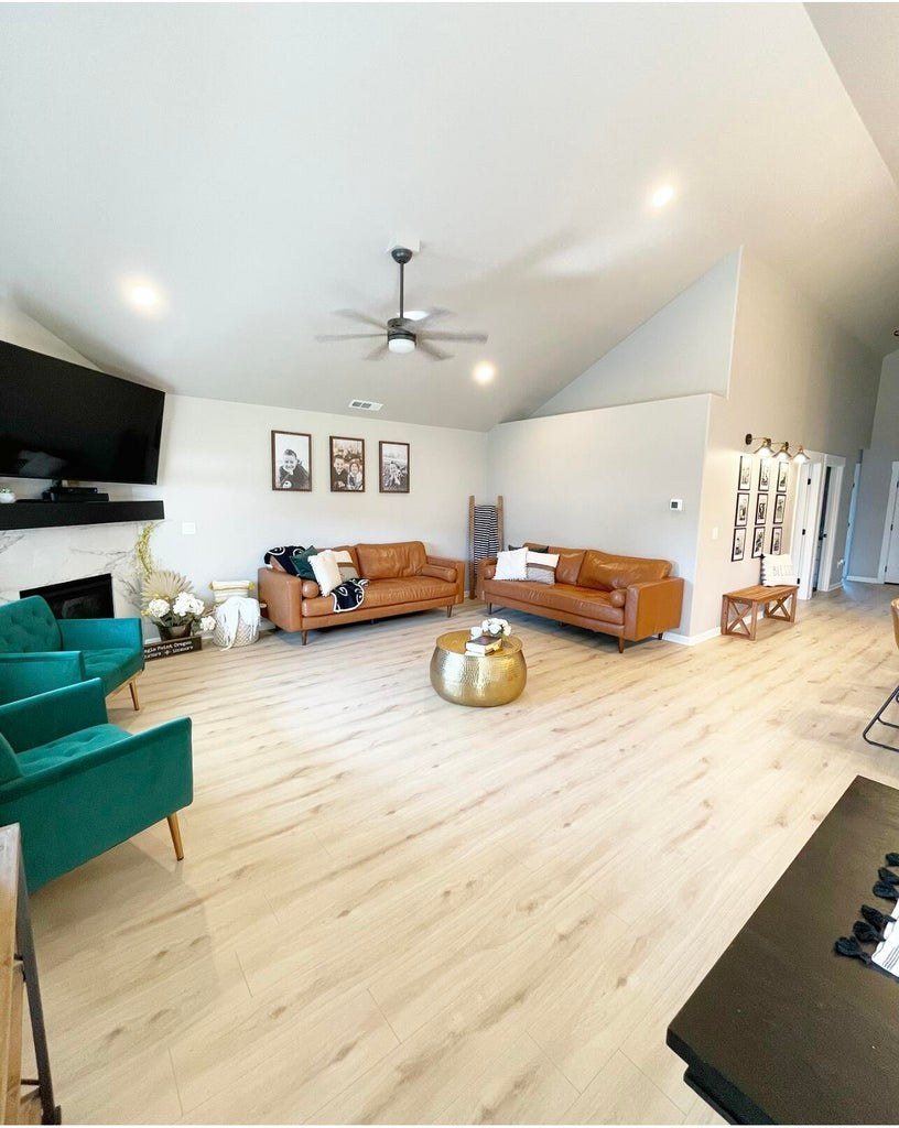 Furnished living room with a gas fireplace, vaulted ceiling and wide-plank floors