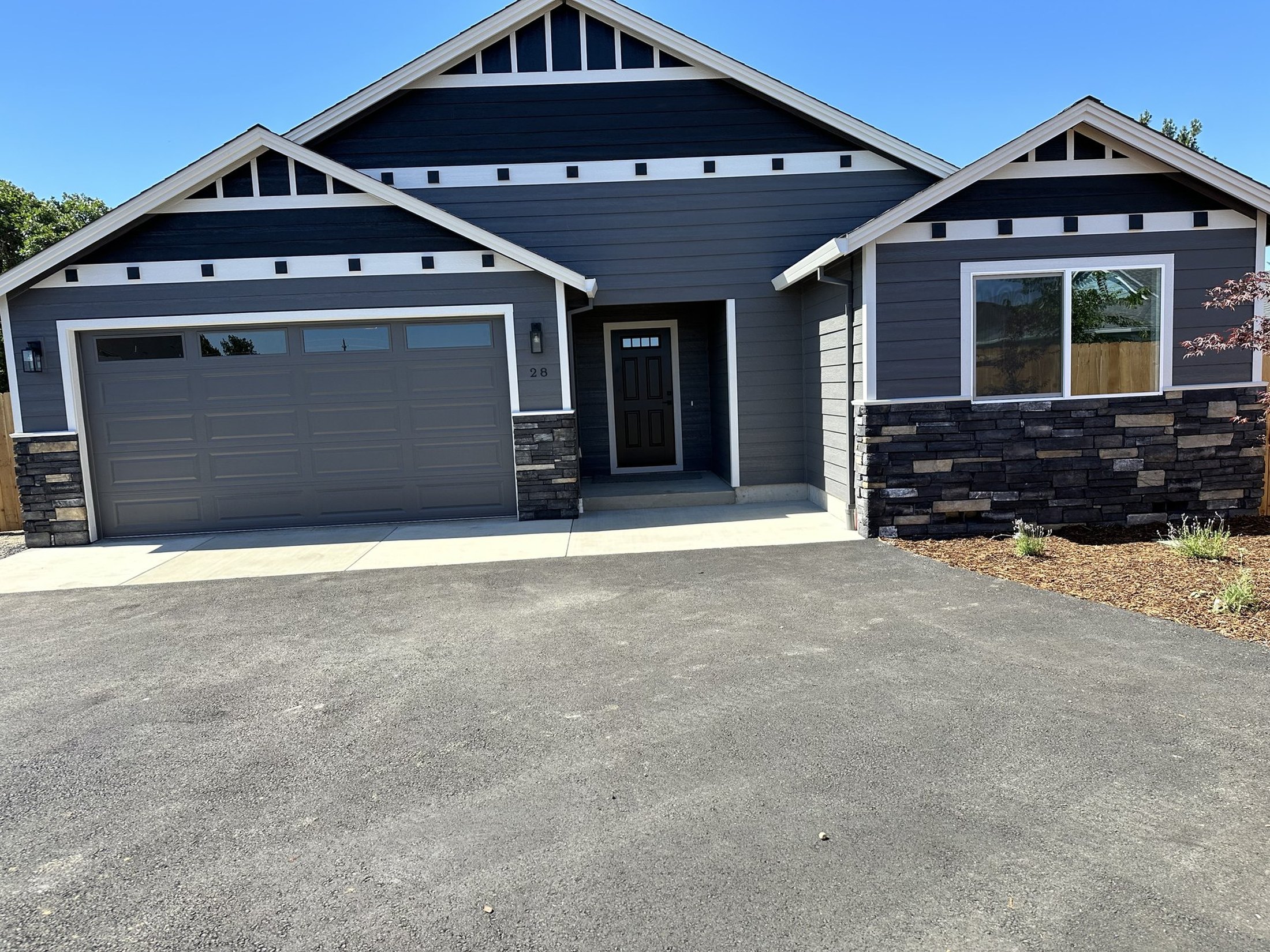 Finished craftsman home — gabled entry, attached garage, stone base and trim detail. Built by Blackthorn Builders, Portland metro.